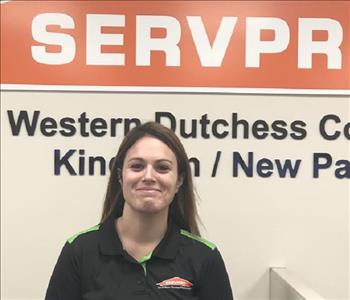 A profile photo of a smiling female employee in a black and green SERVPRO shirt