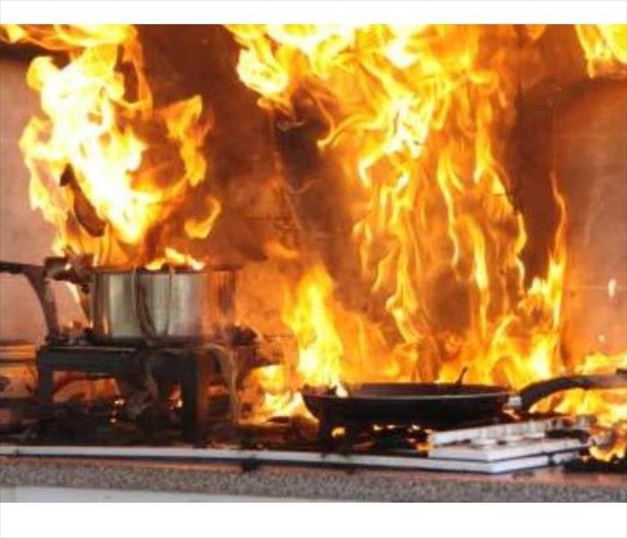 2 pots fully engulfed in flames and smoke on top of a stove