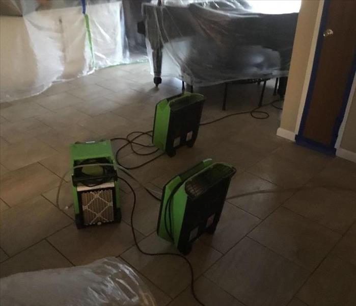 SERVPRO drying equipment set up in a living room.