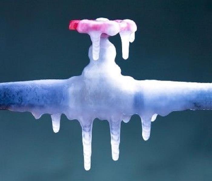 A water pipe and valve frozen and covered in ice