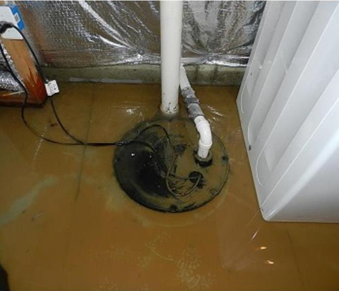 Water pooled on a basement floor due to a malfunctioning sump pump