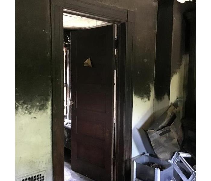 A soot laden interior doorway and walls after a fire occurred